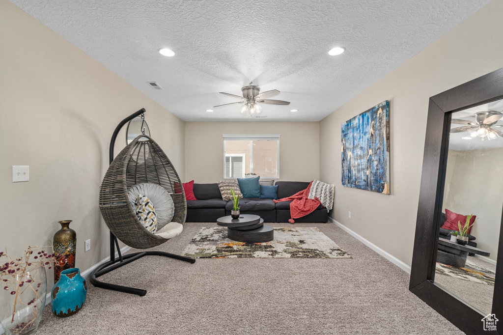 Interior space featuring ceiling fan, carpet flooring, and a textured ceiling