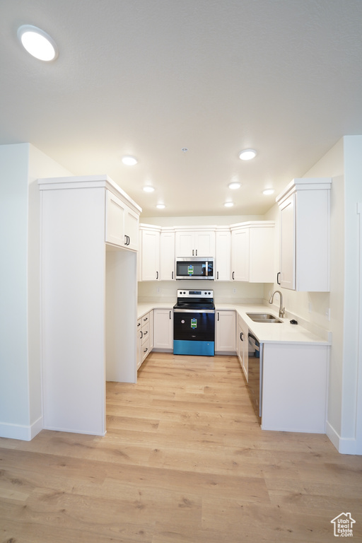 Kitchen featuring light hardwood / wood-style floors, stainless steel appliances, and white cabinets