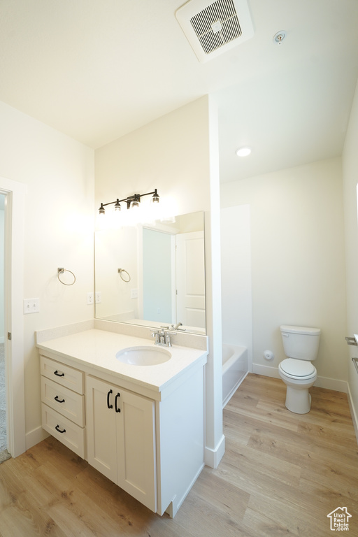 Bathroom featuring toilet, vanity, and hardwood / wood-style flooring