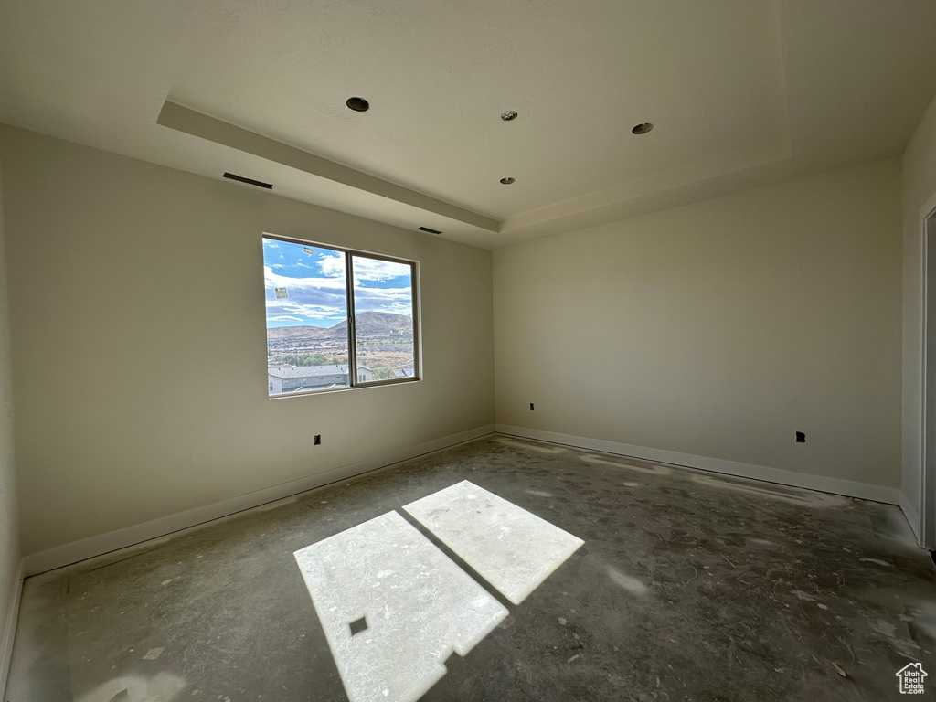 Empty room featuring a raised ceiling