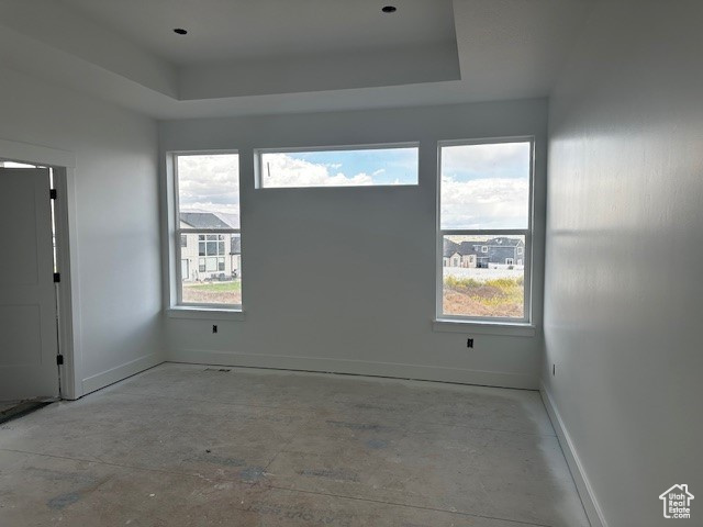 Empty room with a tray ceiling and plenty of natural light