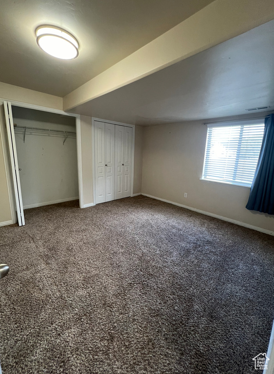 Unfurnished bedroom featuring two closets and carpet flooring