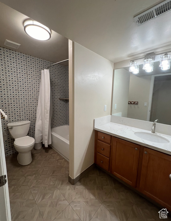 Full bathroom with vanity, shower / tub combo with curtain, and toilet