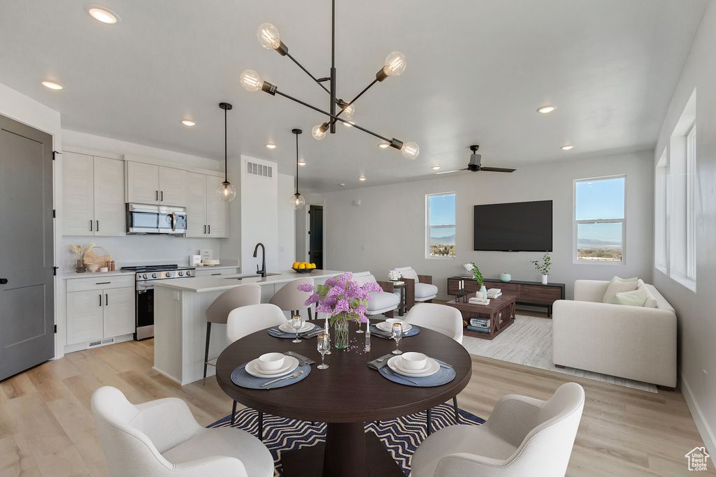 Dining area featuring sink, light hardwood / wood-style flooring, and ceiling fan