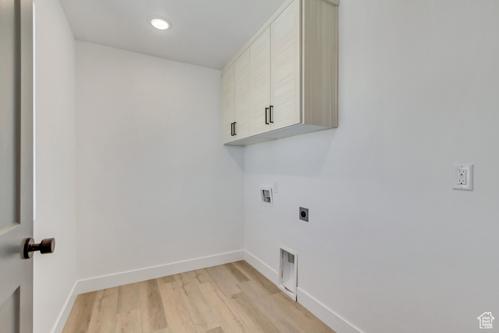 Laundry room with light hardwood / wood-style floors, electric dryer hookup, cabinets, and hookup for a washing machine