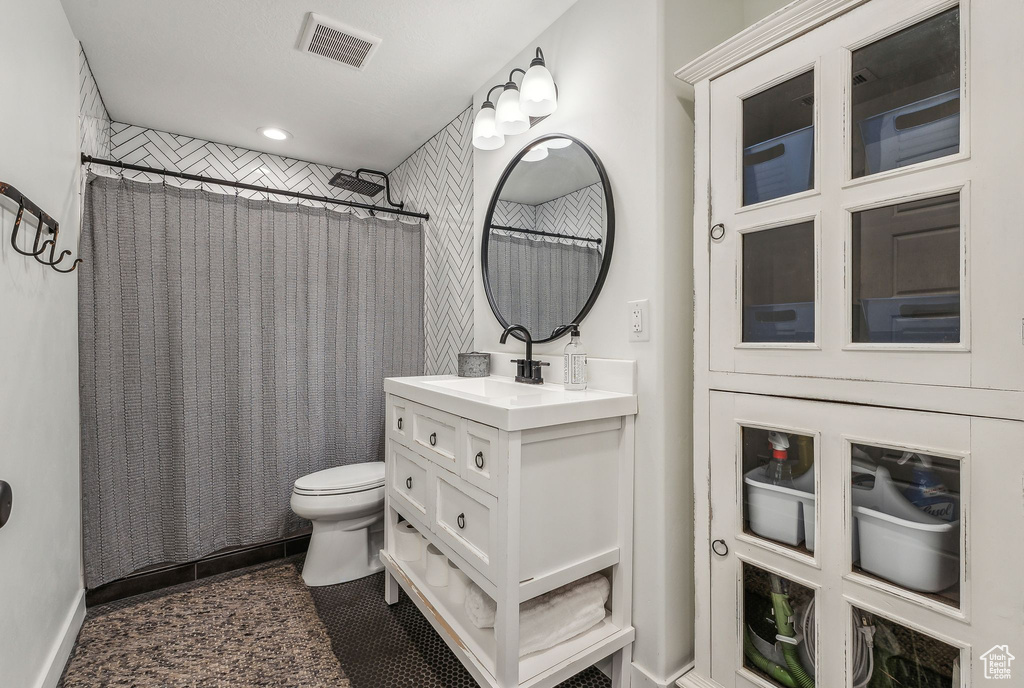 Bathroom featuring toilet, vanity, and tile patterned floors