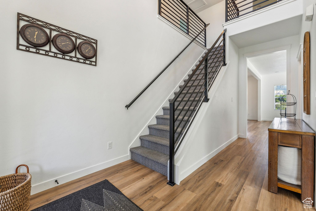 Staircase featuring hardwood / wood-style flooring and a high ceiling