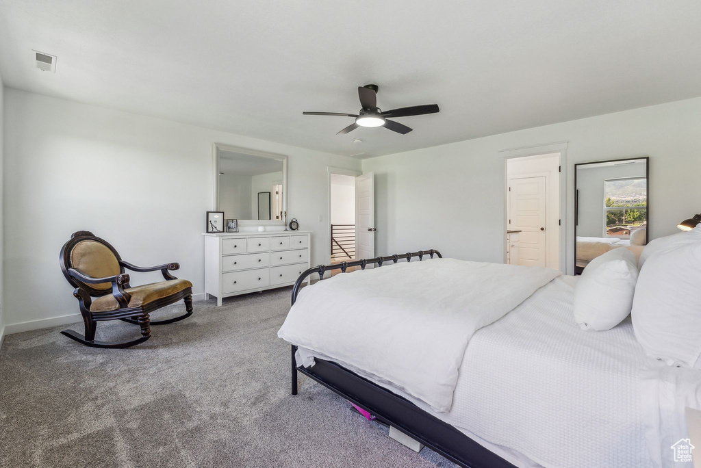 Bedroom with ceiling fan, light carpet, and connected bathroom