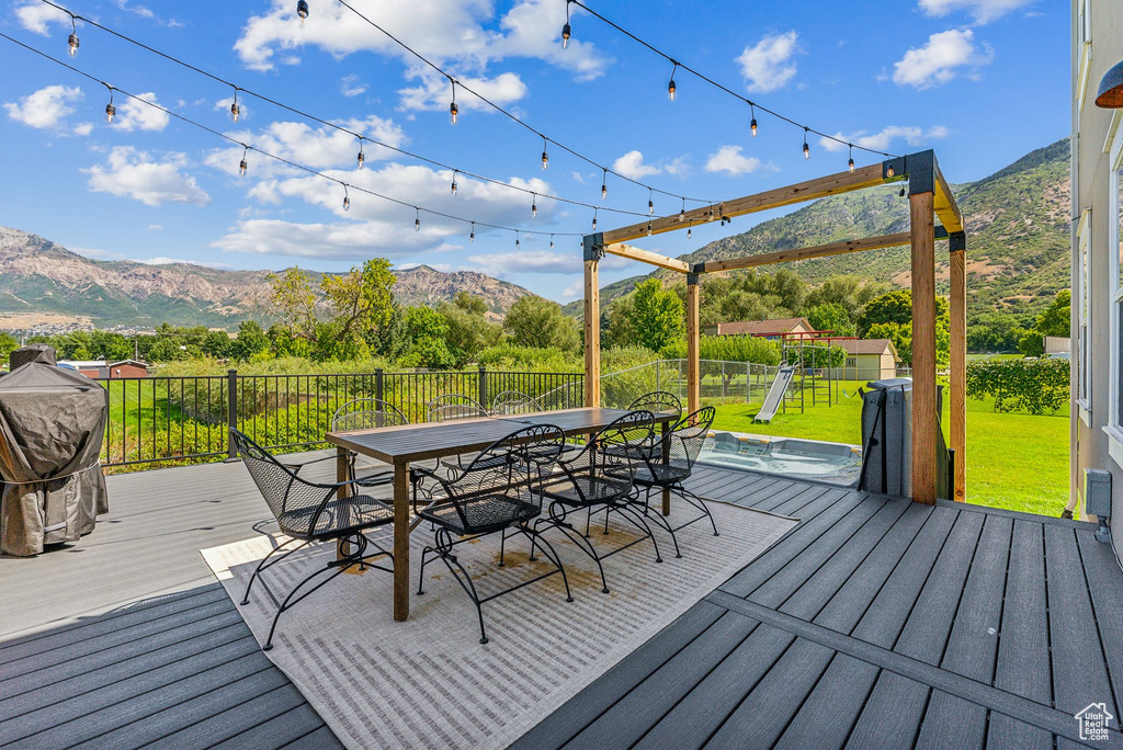 Wooden terrace featuring a mountain view and a playground