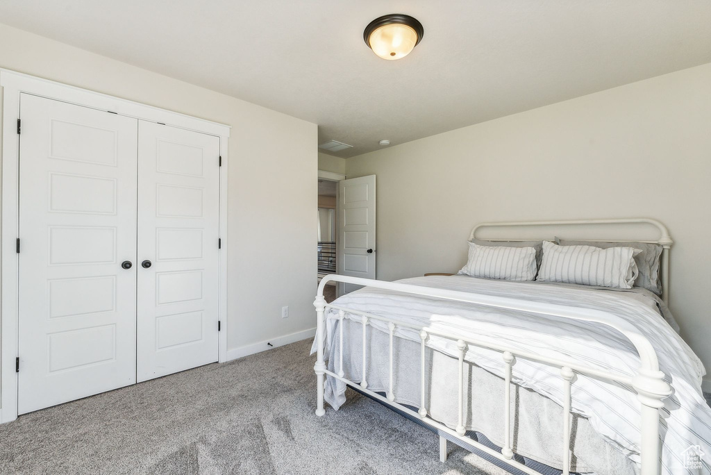 Carpeted bedroom featuring a closet