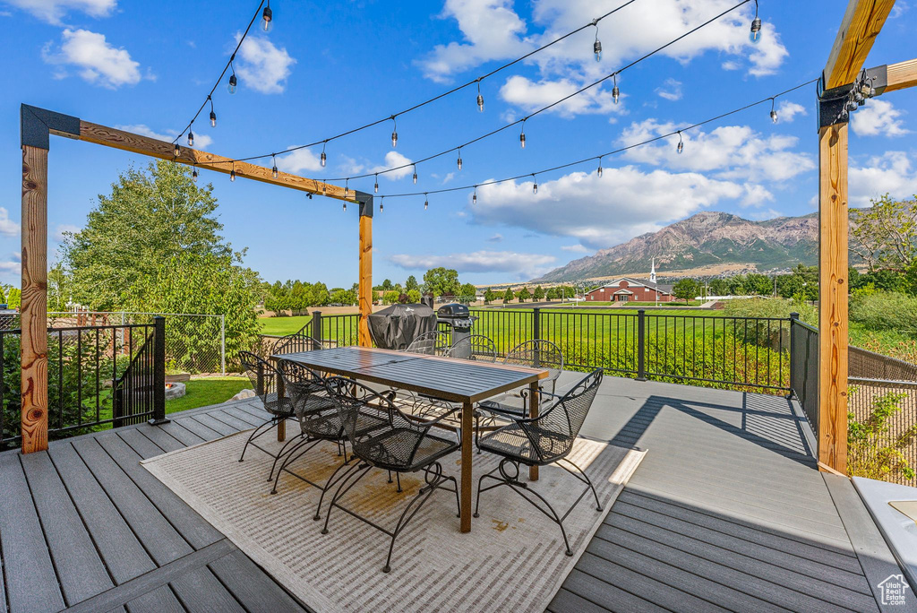 Wooden deck with a mountain view and a yard