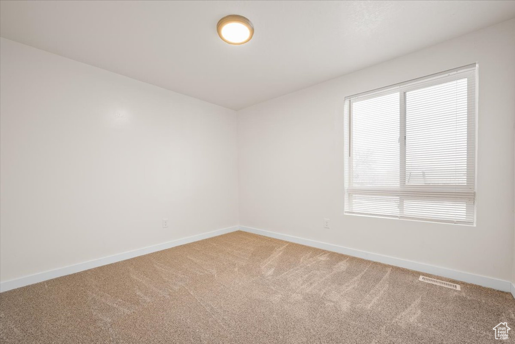 Carpeted spare room with a healthy amount of sunlight