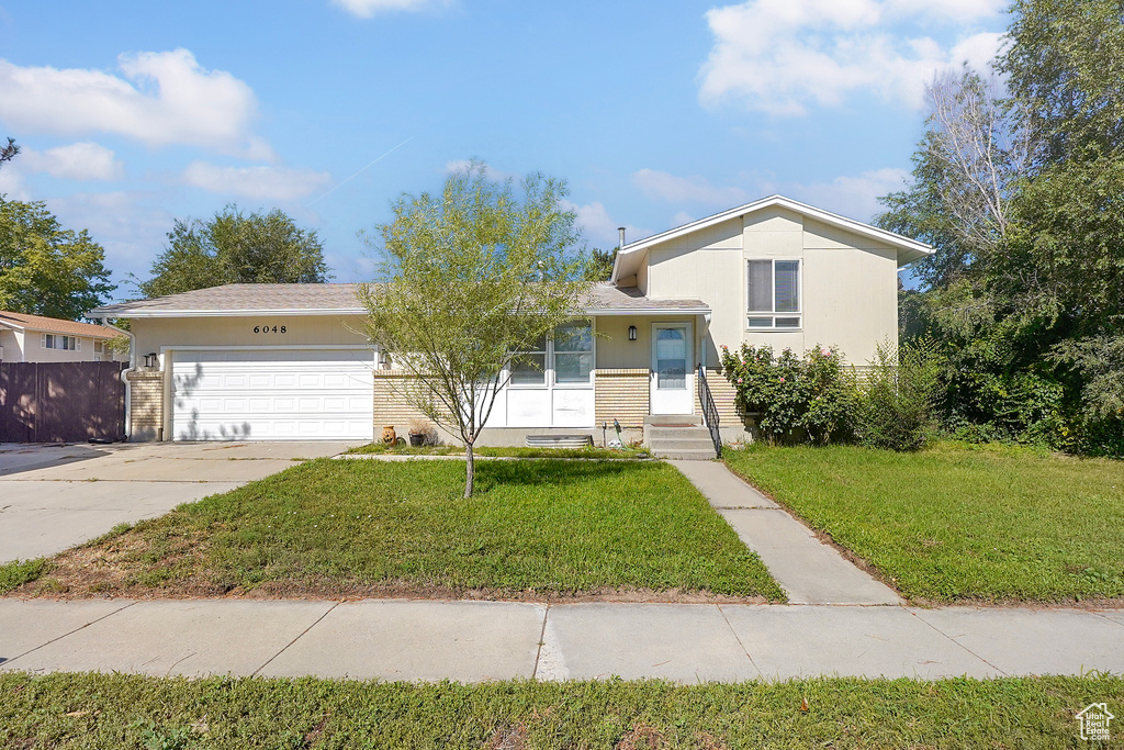 View of front of home featuring a garage and a front lawn