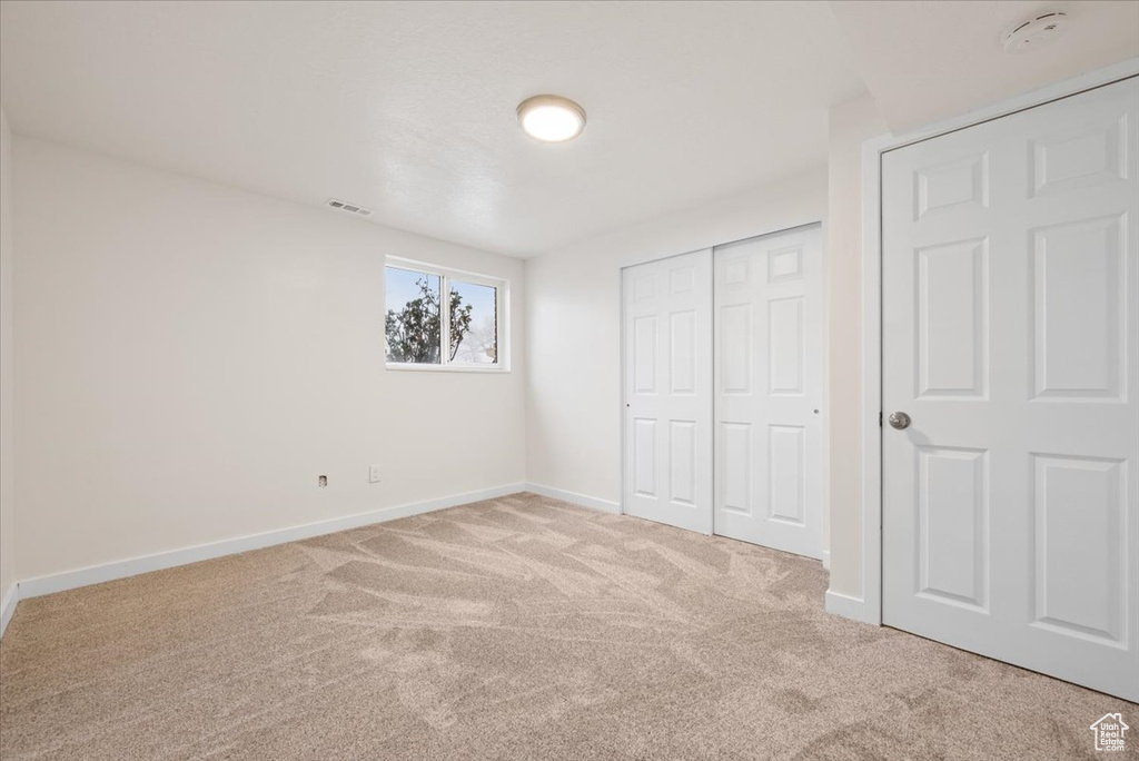 Unfurnished bedroom featuring light carpet