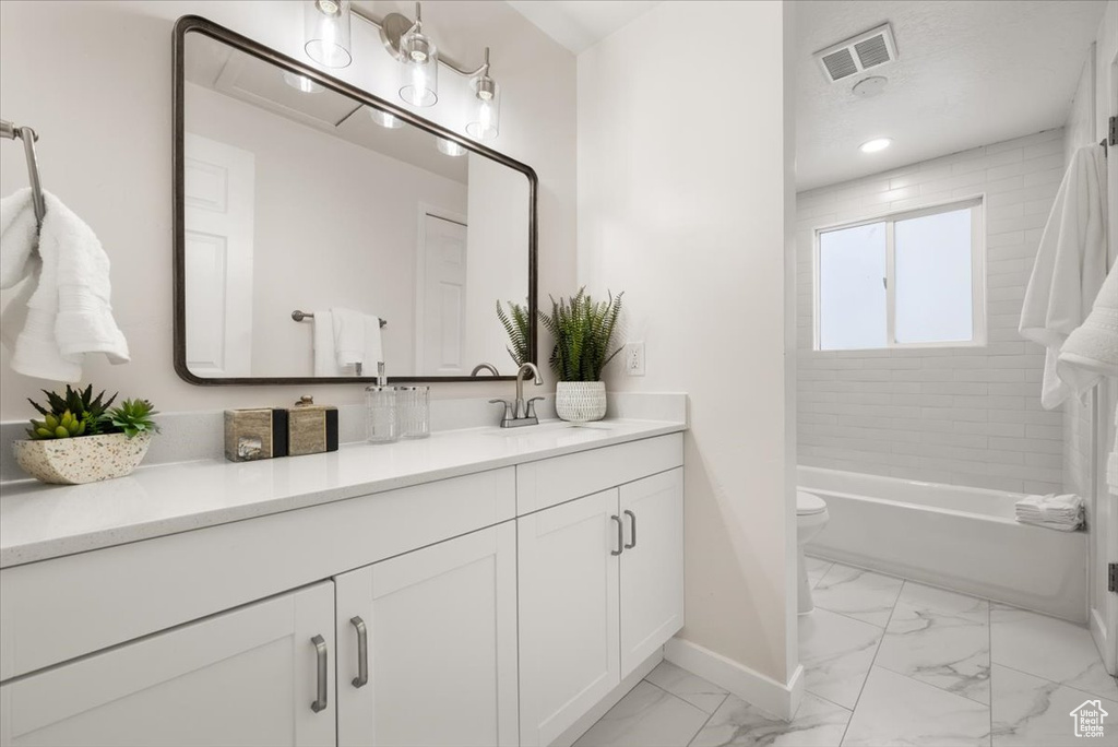 Bathroom featuring tile patterned flooring, toilet, and vanity