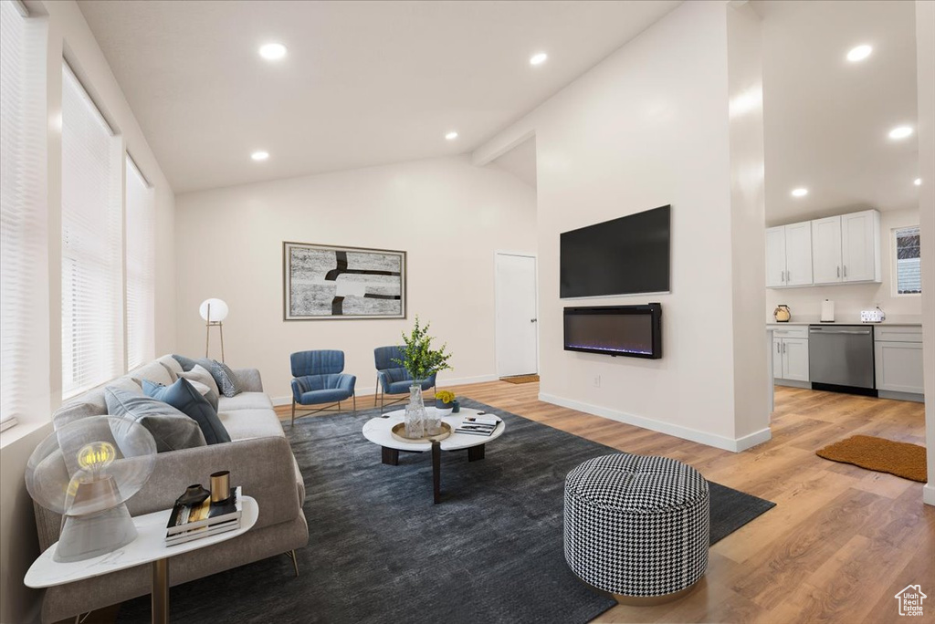 Living room featuring light hardwood / wood-style floors, beam ceiling, and high vaulted ceiling