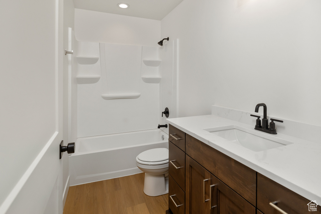 Full bathroom with shower / bath combination, wood-type flooring, toilet, and vanity