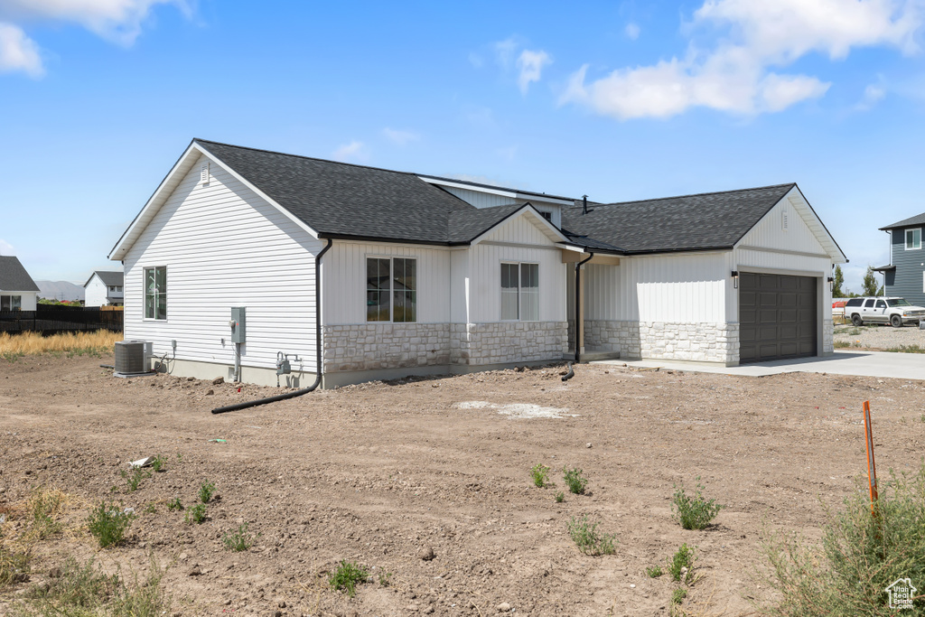 View of front of house featuring cooling unit and a garage