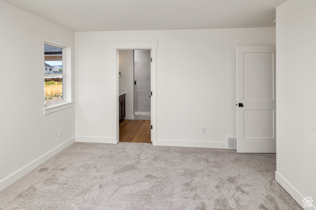 Unfurnished bedroom with light colored carpet