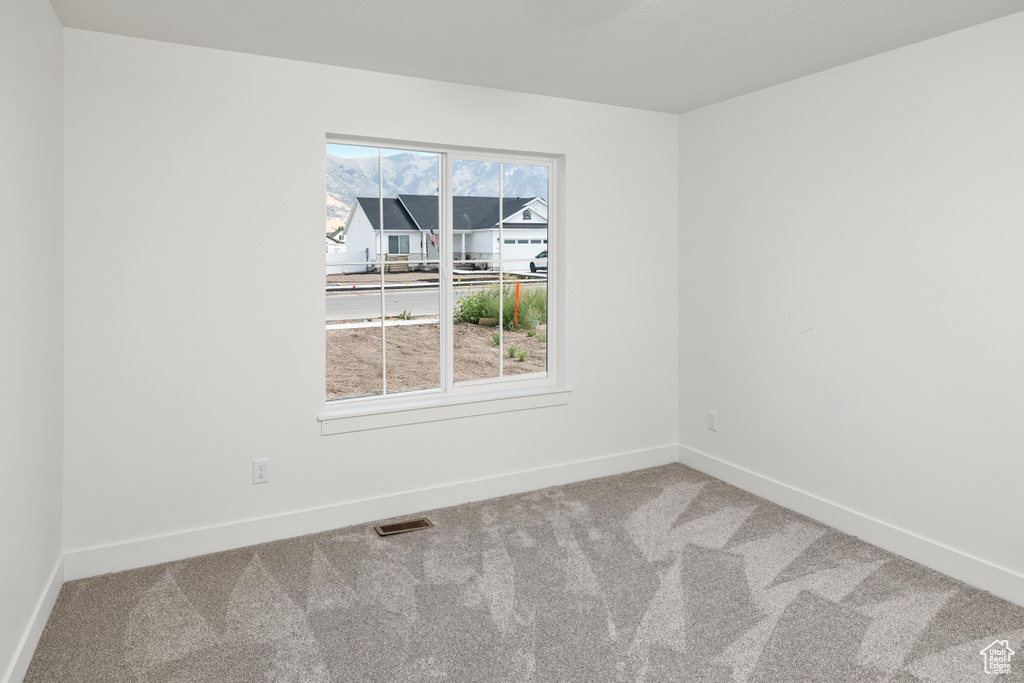 Carpeted empty room featuring a wealth of natural light