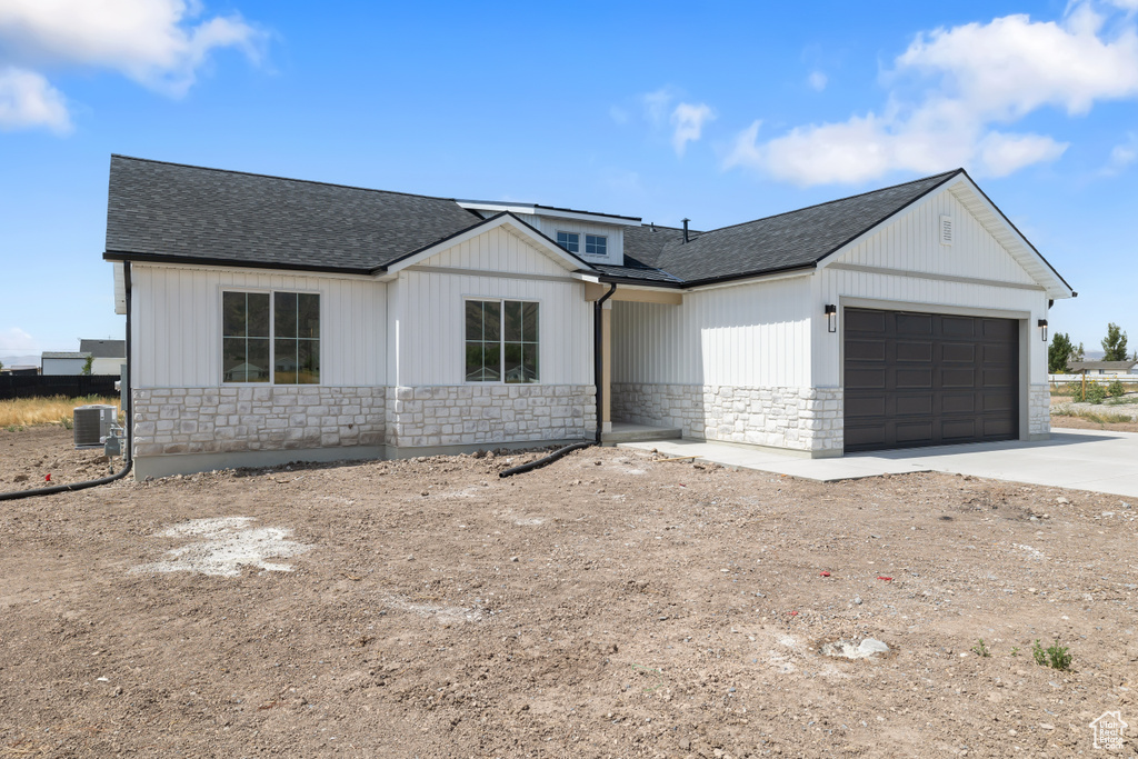 View of front of property featuring cooling unit and a garage