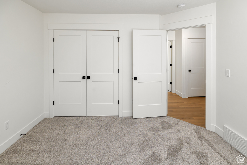 Unfurnished bedroom featuring light wood-type flooring and a closet