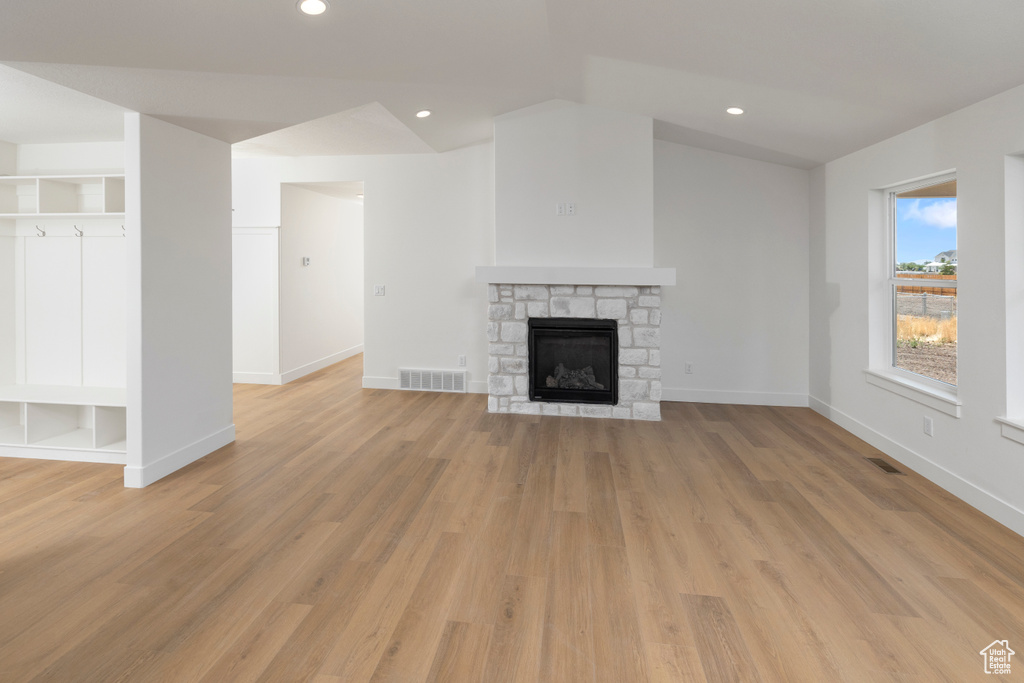 Unfurnished living room featuring a fireplace, light hardwood / wood-style flooring, and built in features