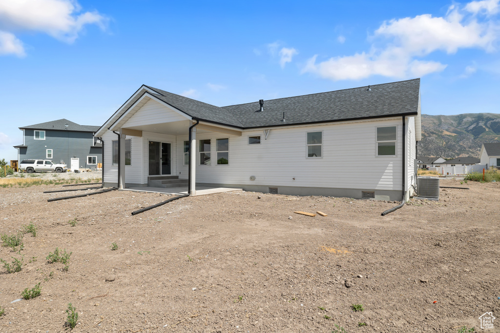 Back of house with a mountain view, a patio, and central AC