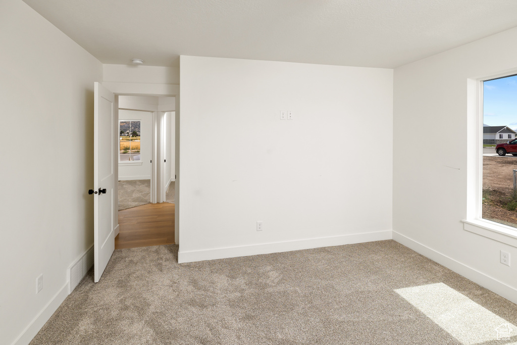 Carpeted empty room featuring a healthy amount of sunlight