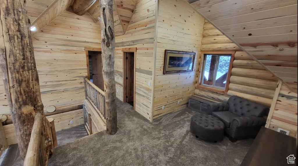 Interior space with carpet, wood walls, lofted ceiling, and wooden ceiling