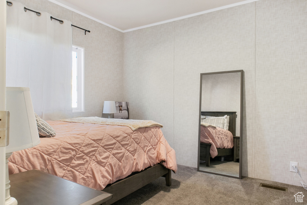 Carpeted bedroom featuring ornamental molding