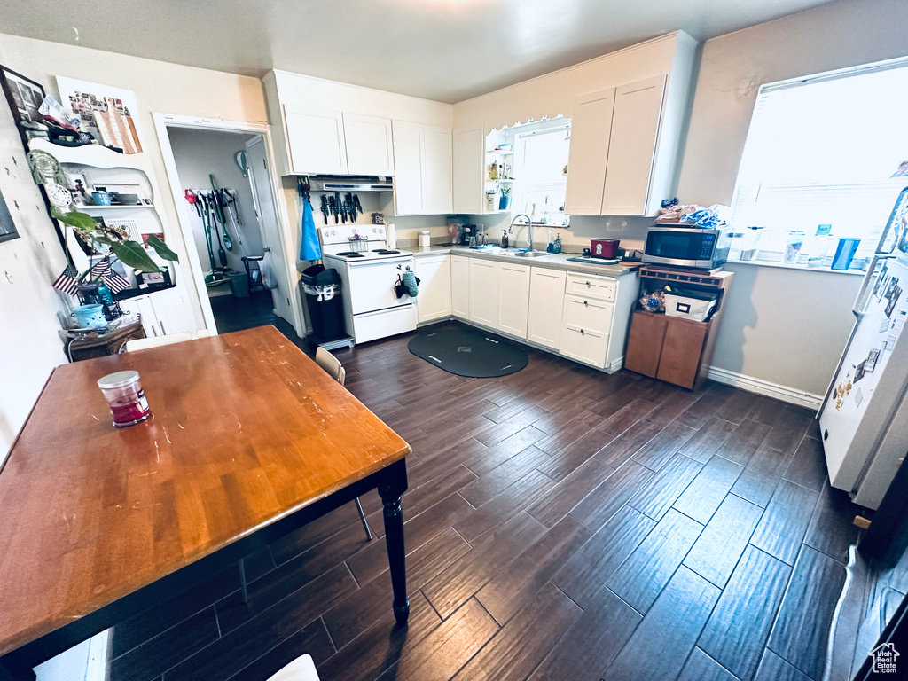 Kitchen featuring white cabinets, dark hardwood / wood-style floors, and white electric range