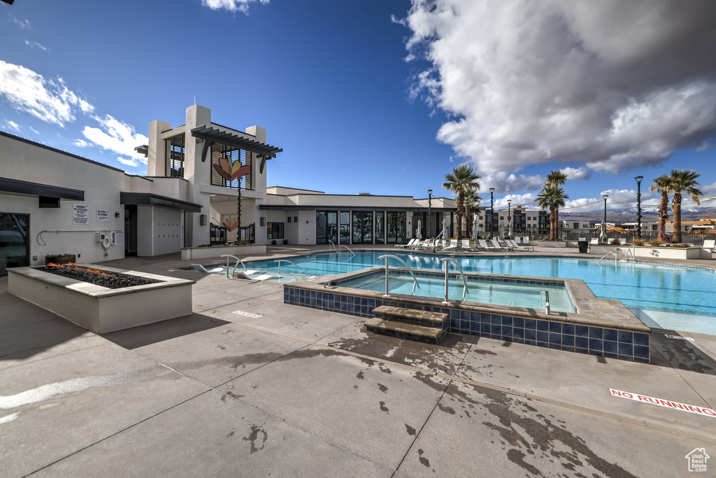 View of swimming pool with a hot tub