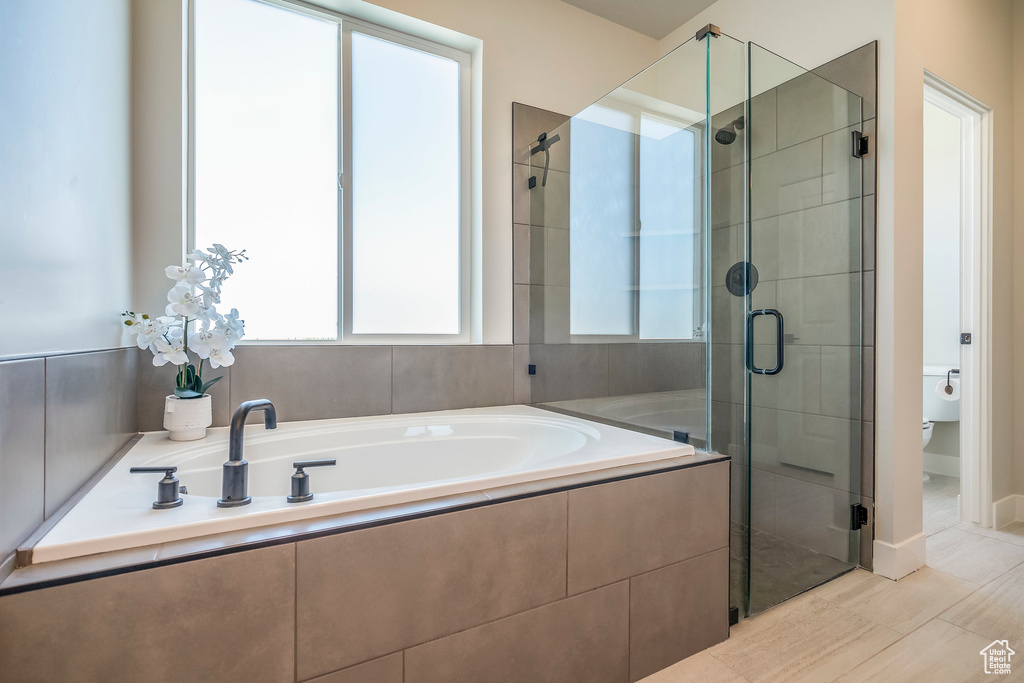 Bathroom featuring toilet, independent shower and bath, and tile patterned floors