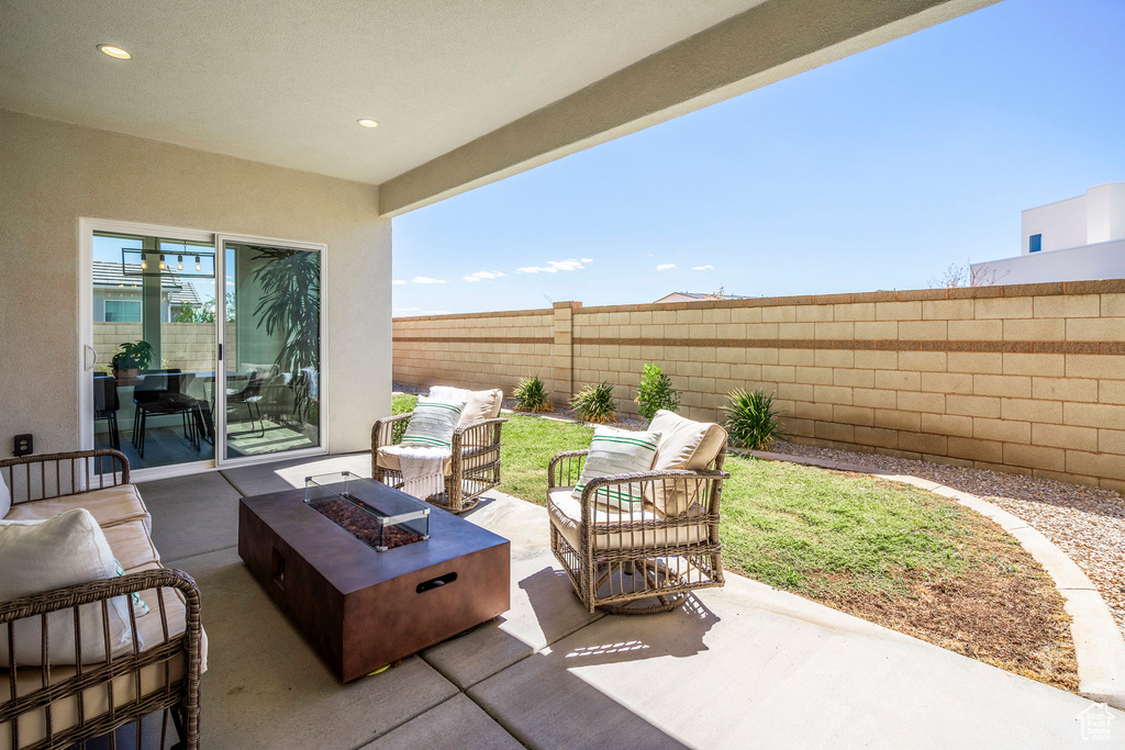 View of patio with an outdoor living space with a fire pit