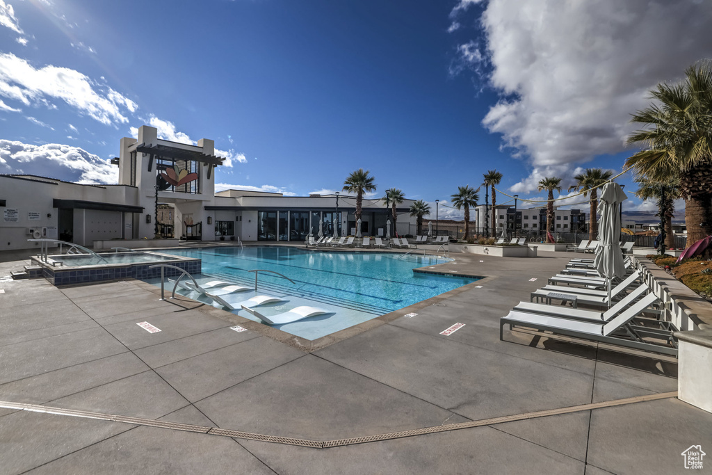 View of pool with a patio area and a hot tub