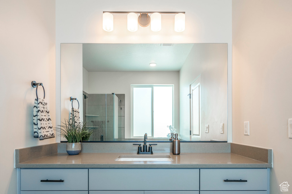 Bathroom featuring an enclosed shower and vanity