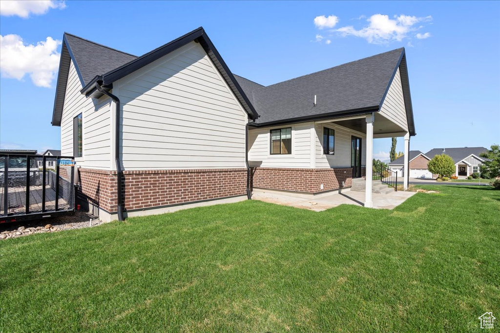 Back of house with a patio and a yard