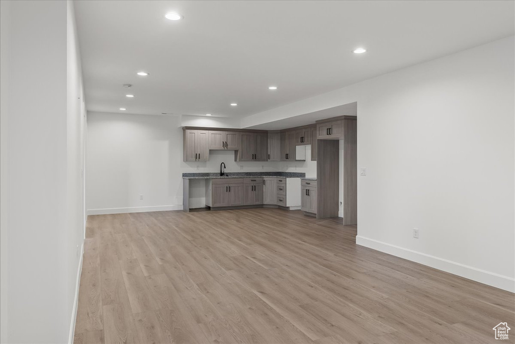 Unfurnished living room with sink and light hardwood / wood-style flooring