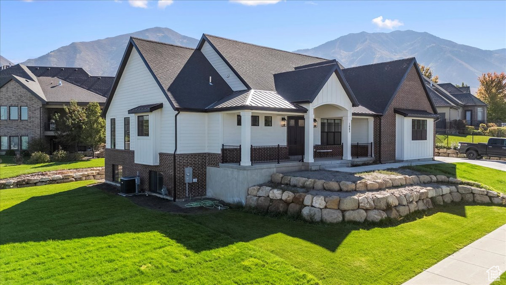 View of front of home featuring a mountain view and a front lawn