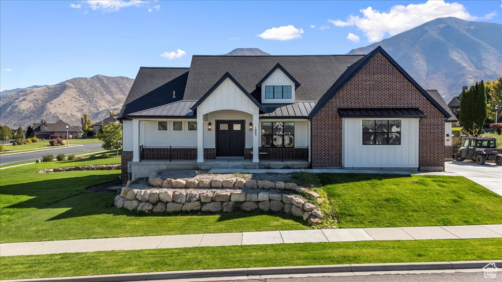 Modern farmhouse style home featuring a front yard and a mountain view