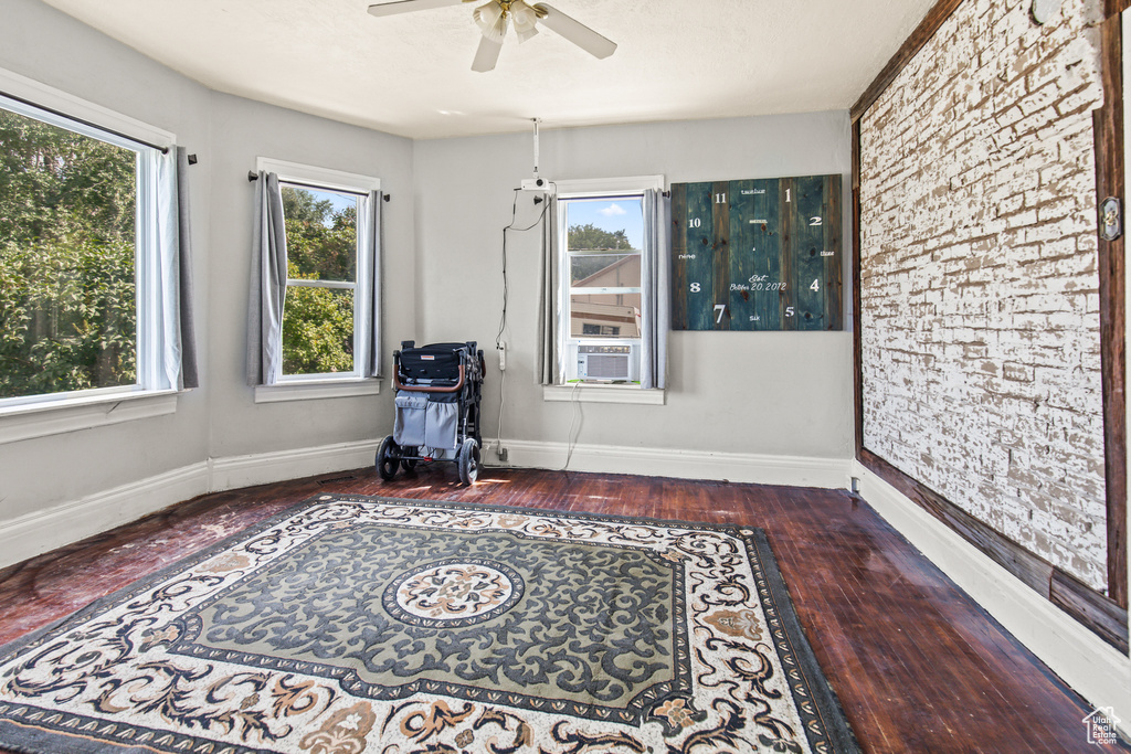 Sitting room featuring ceiling fan, cooling unit, and dark hardwood / wood-style floors