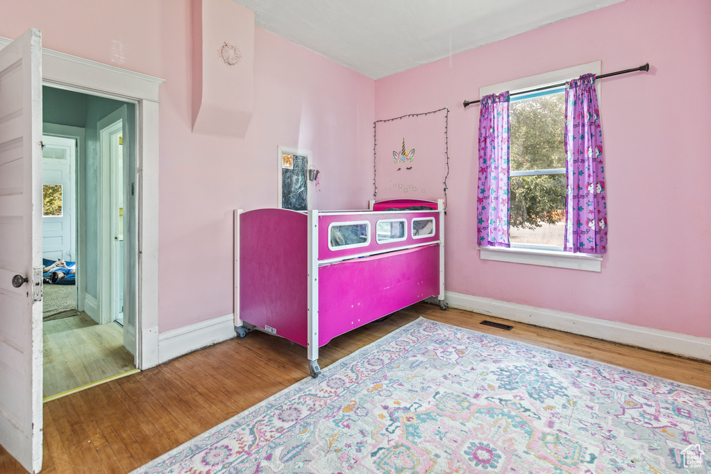 Bedroom with hardwood / wood-style flooring