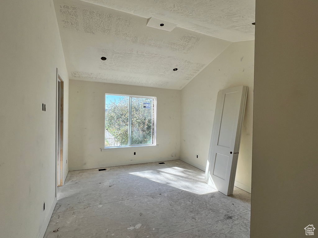 Unfurnished room featuring lofted ceiling