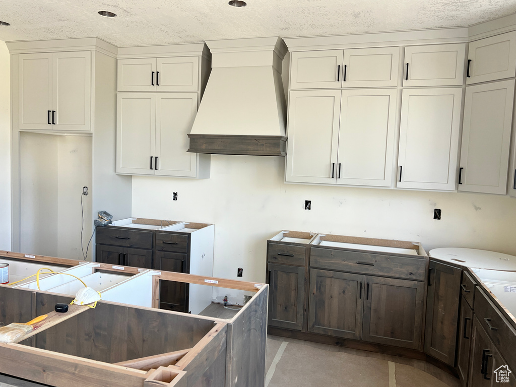 Kitchen featuring premium range hood and a textured ceiling