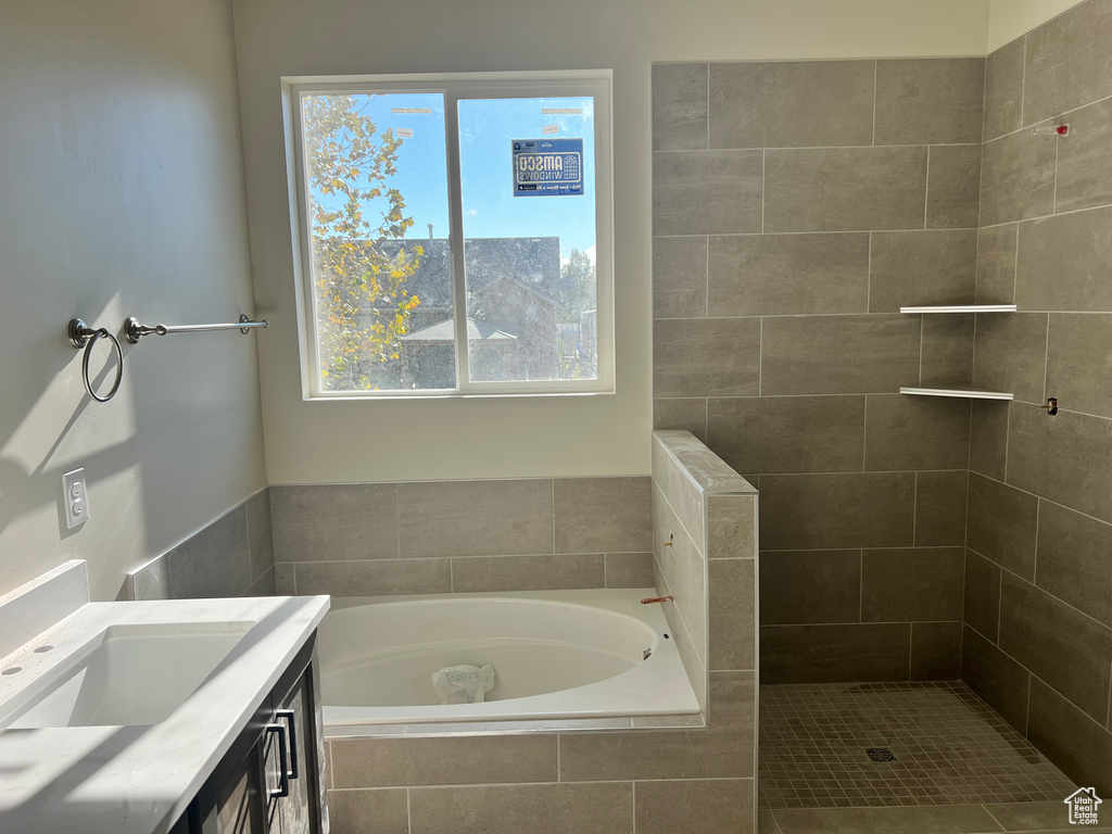 Bathroom with vanity and tiled tub