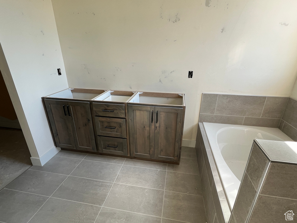 Bathroom featuring tile patterned floors and a relaxing tiled tub