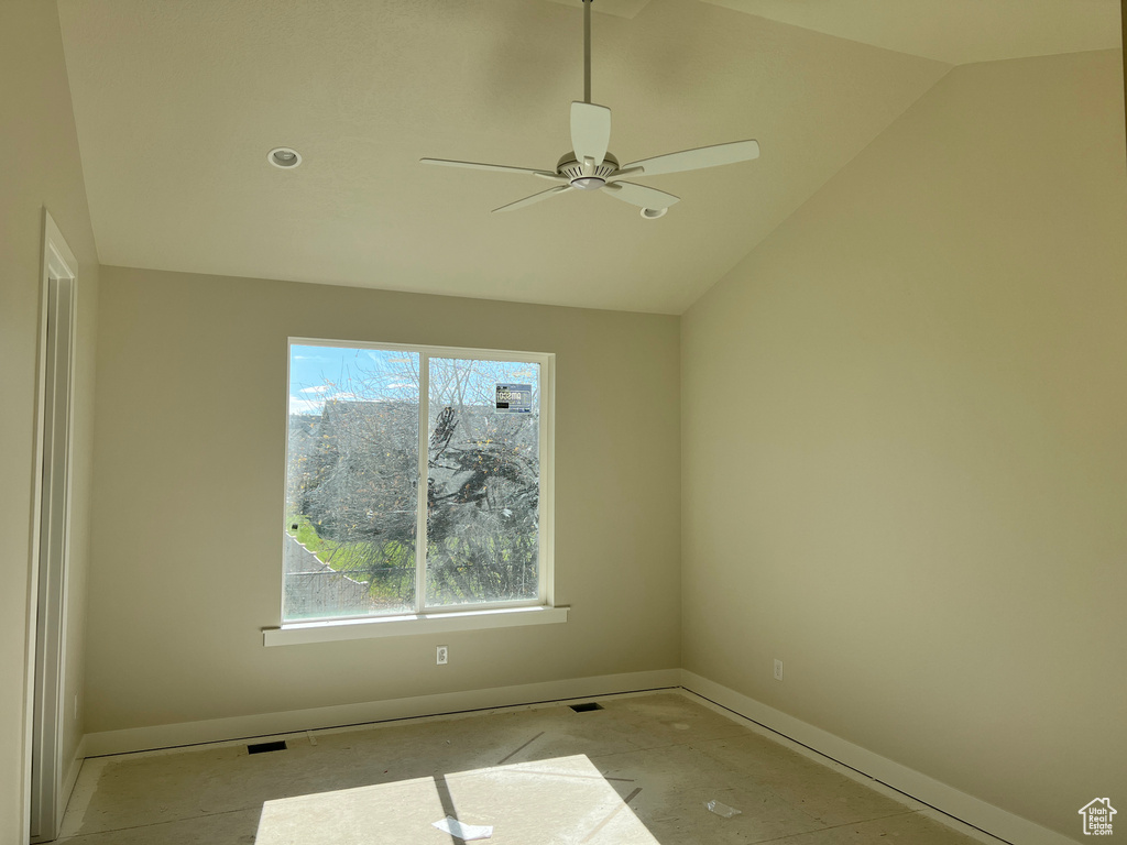 Spare room featuring vaulted ceiling and ceiling fan