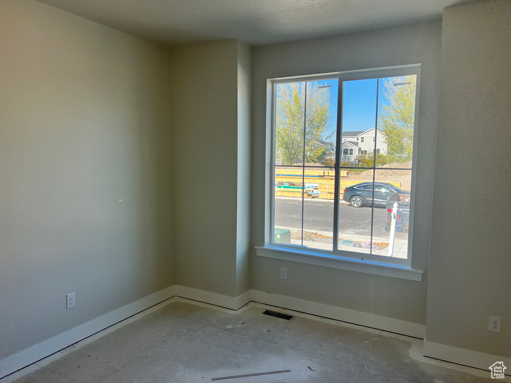 Empty room with a wealth of natural light and a textured ceiling