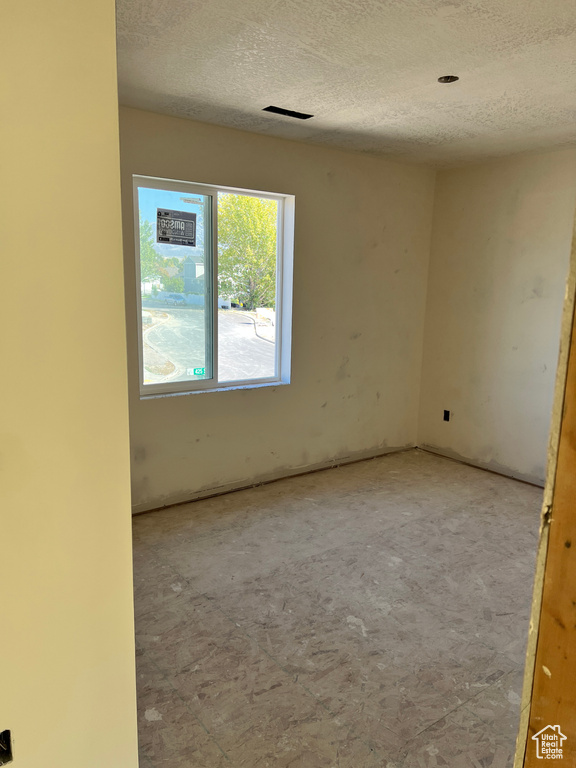 Empty room featuring a textured ceiling